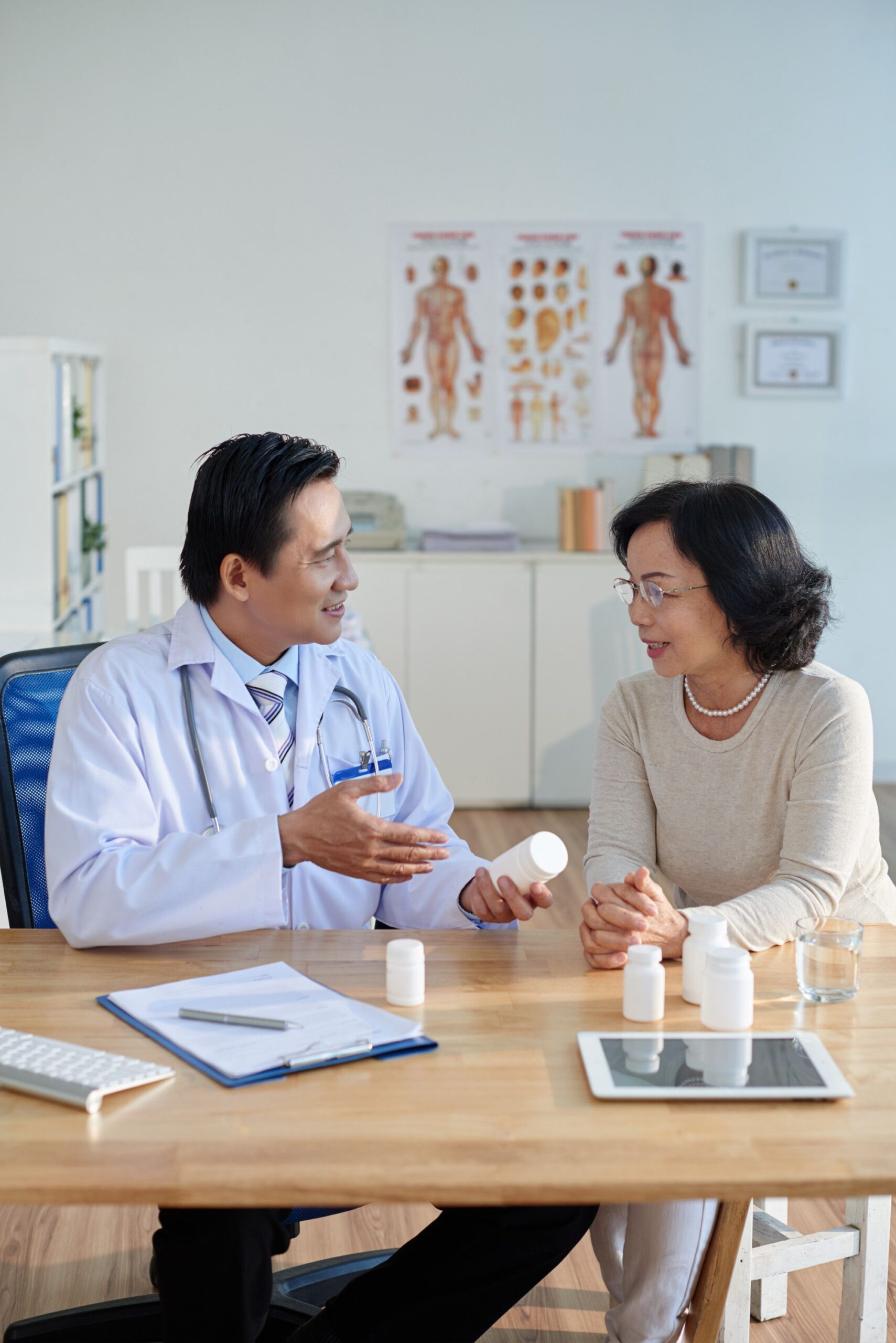 A Doctor And Patient At A Table, Having A Consultation In A Medical Office